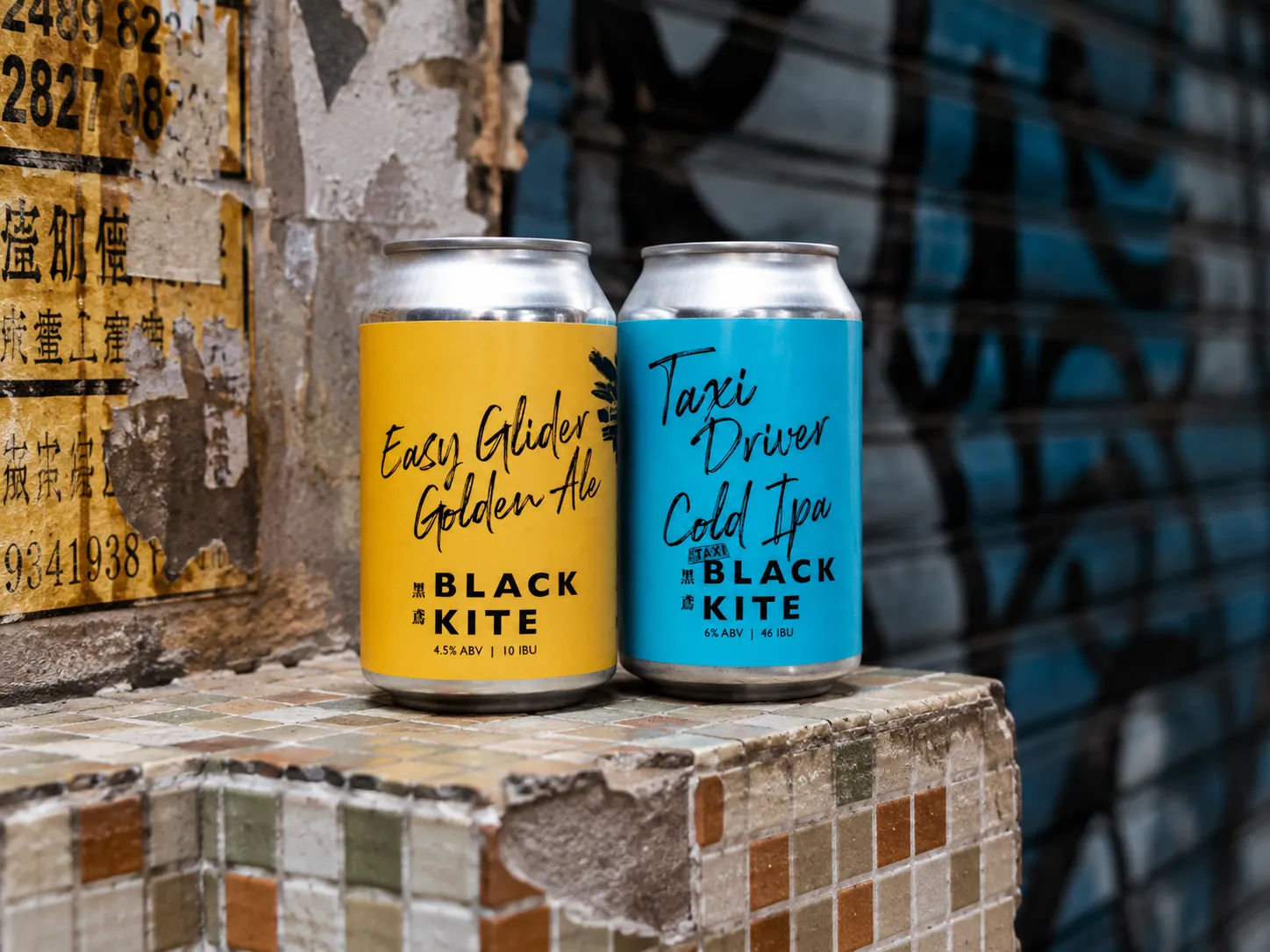 Black Kite Easy Glider and Taxi Driver cans shown together against a city wall