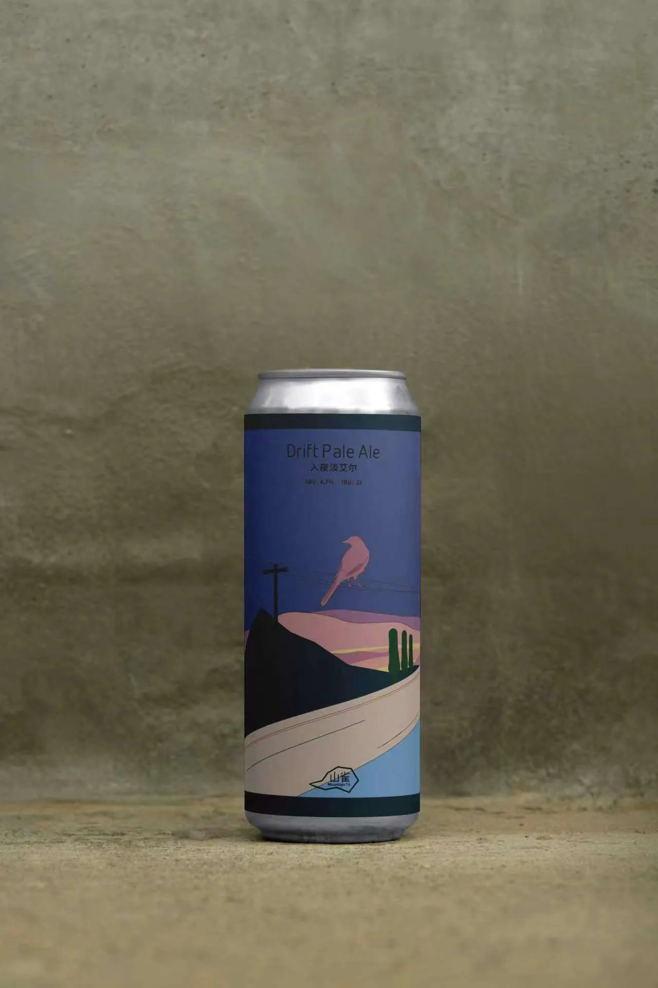 Drift Pale Ale can standing alone against a mineral wall with its bird and dusk landscape visible